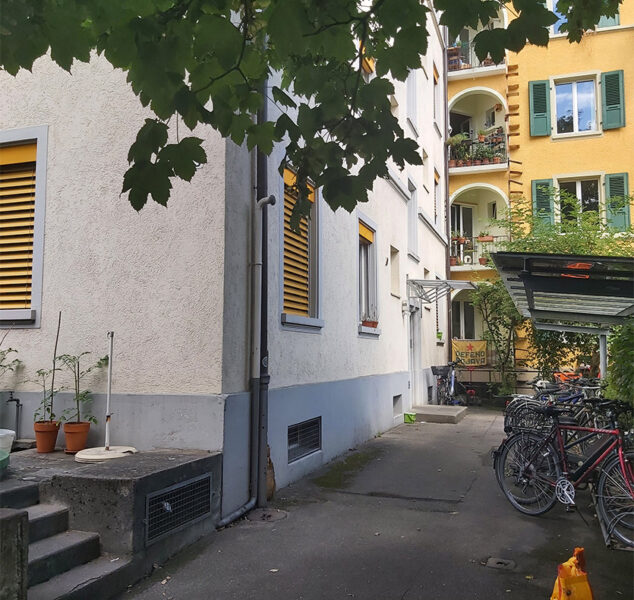 Michel Bauökonomie - Projekt MFH Lorraine - Sicht Hauseingang mit Blick zu einem gelben Haus